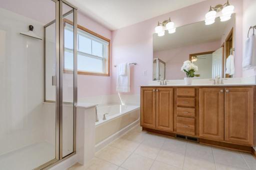 Primary bathroom with separate shower and large soaking tub. Double sinks