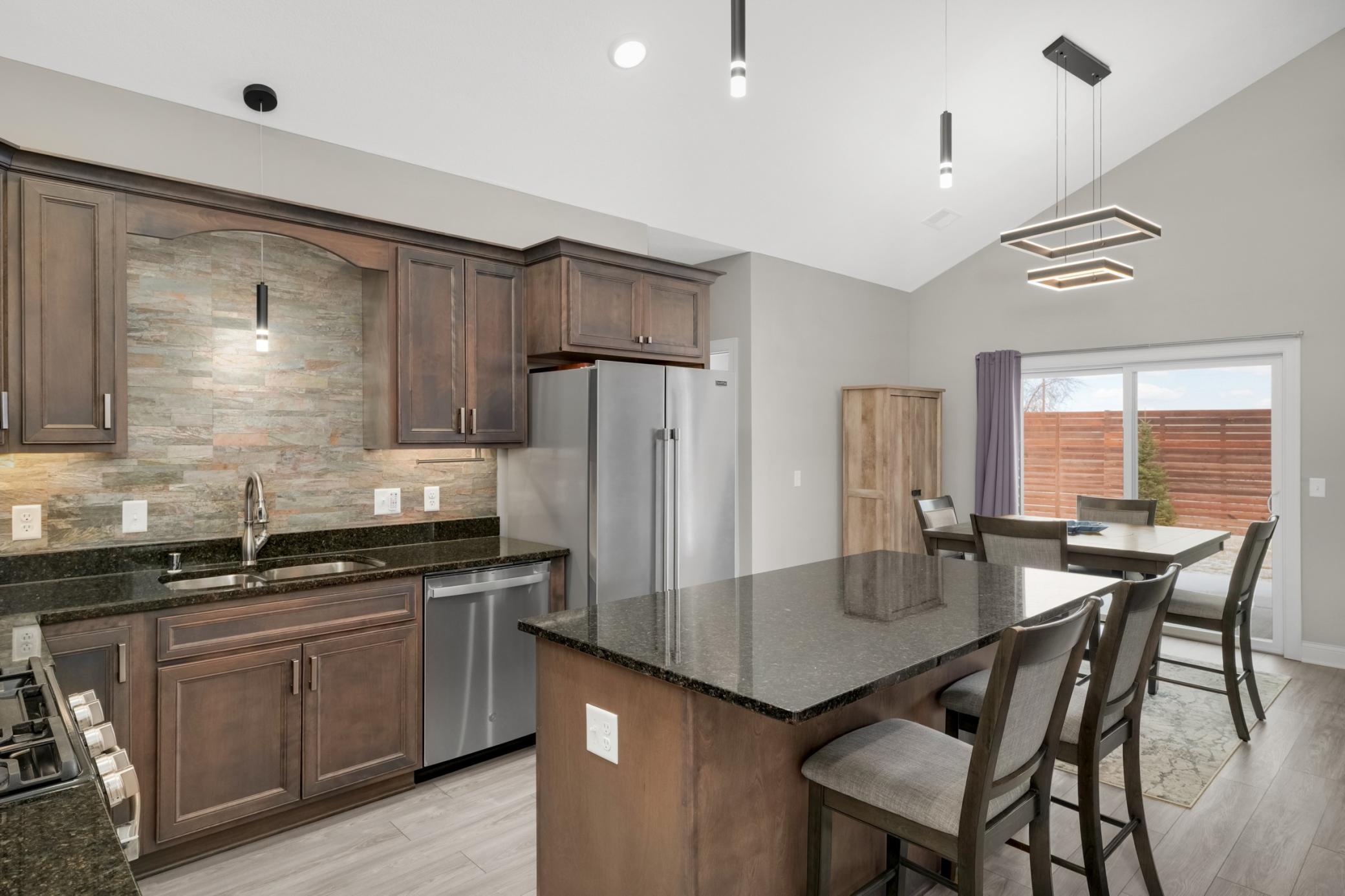 Kitchen features birch cabinets, granite counters, quartz backsplash, under cabinet lighting and stainless steel appliances