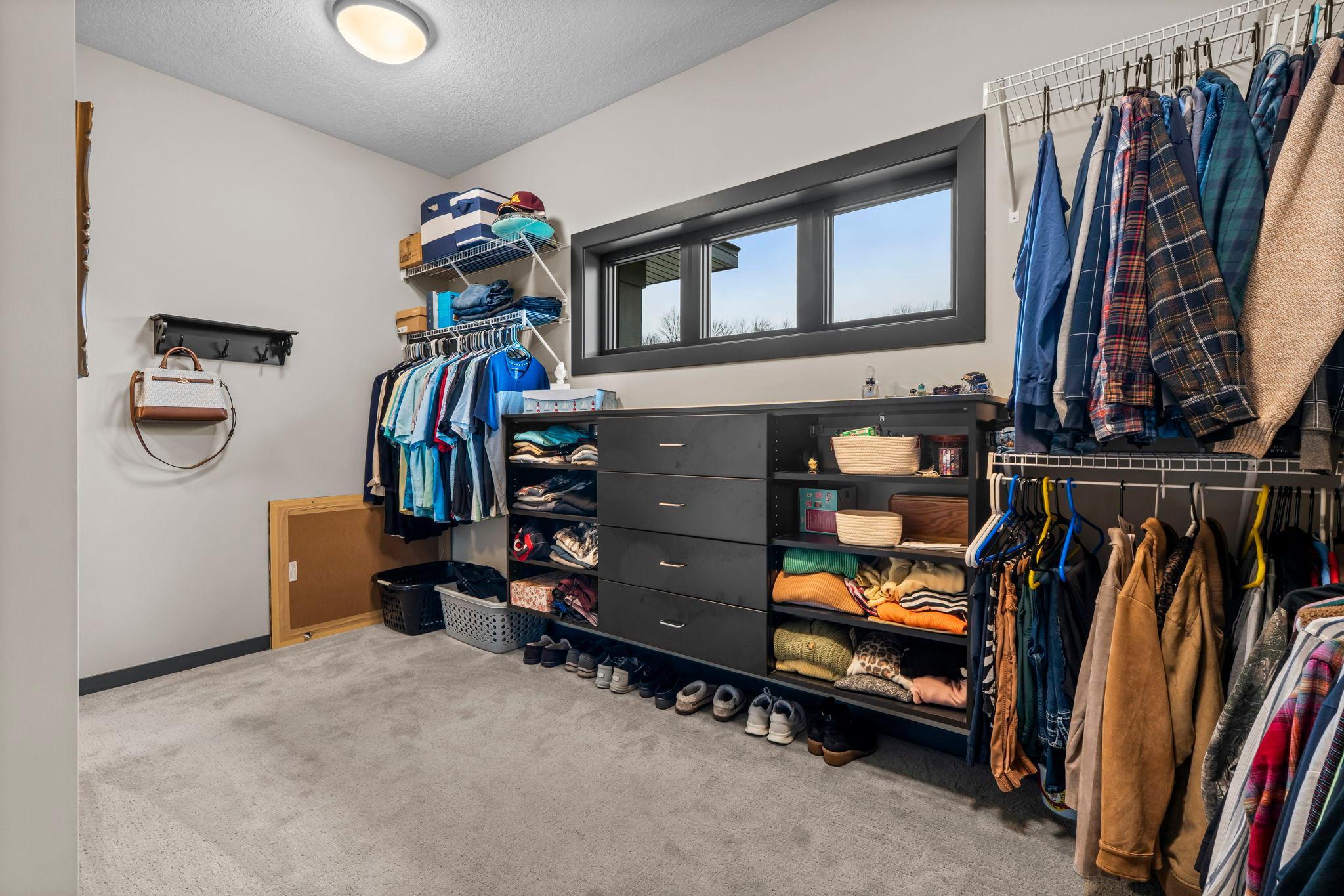 The spacious walk-in closet is brightened by natural light streaming through the window