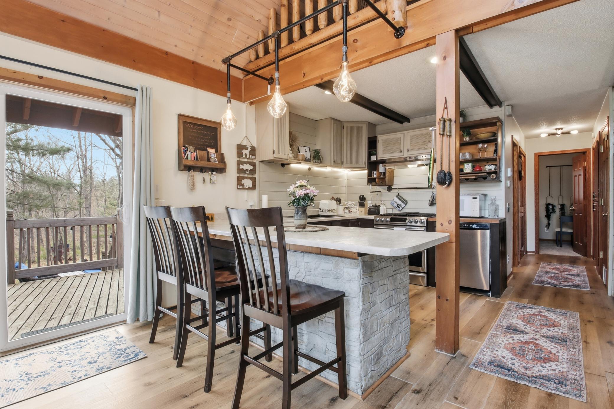 There are multiple patio doors to access the wrap around deck. Beams accent the ceiling.