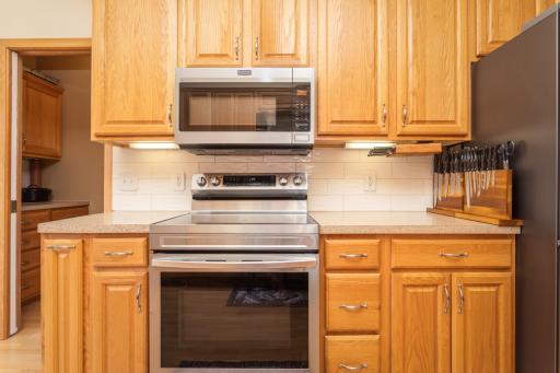 The range is surrounded by warm cabinetry and thoughtful storage