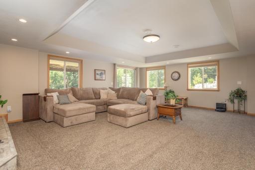 Spacious family room is light and bright with many windows showcasing the view