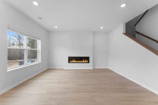 Family room features electric fireplace and blinds