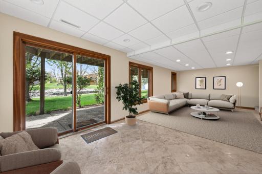 Family room in lower level has travertine tile and walks out to the spacious backyard.