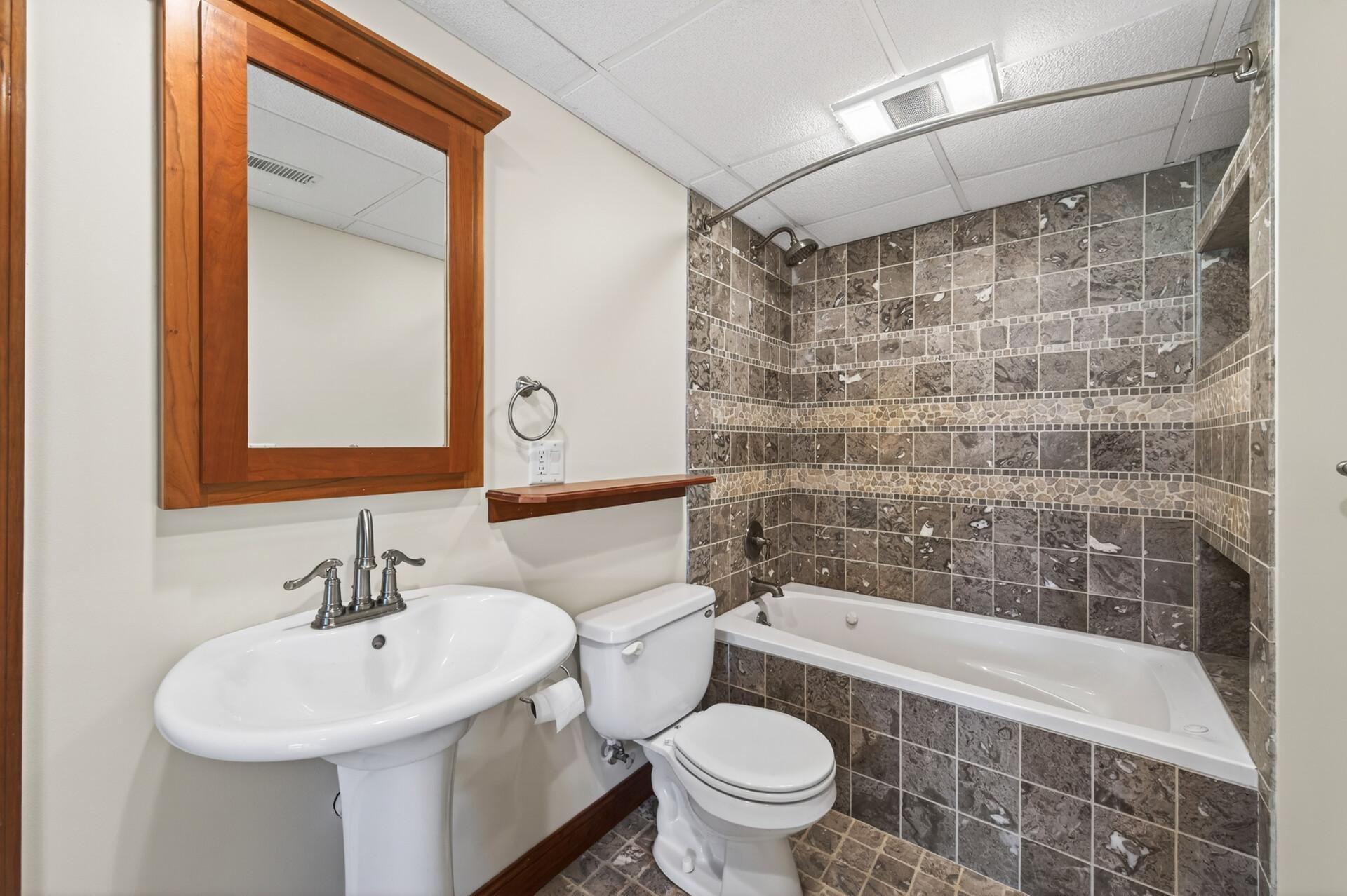 The lower level bath is artfully tiled.