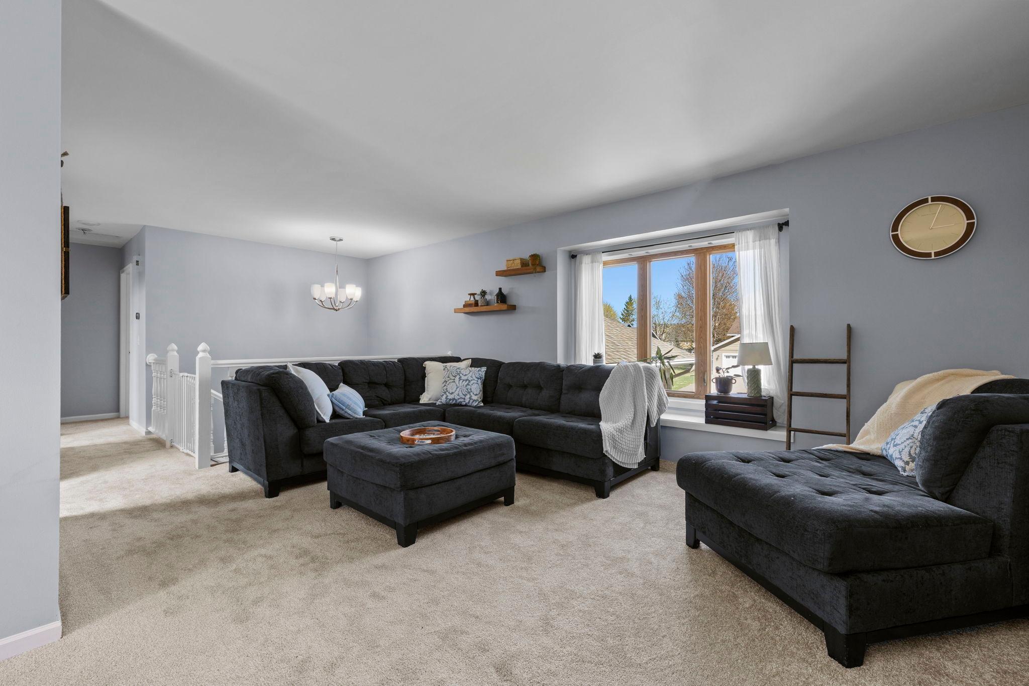 Upstairs, the main living area feels bright and connected with large windows bringing in natural light.