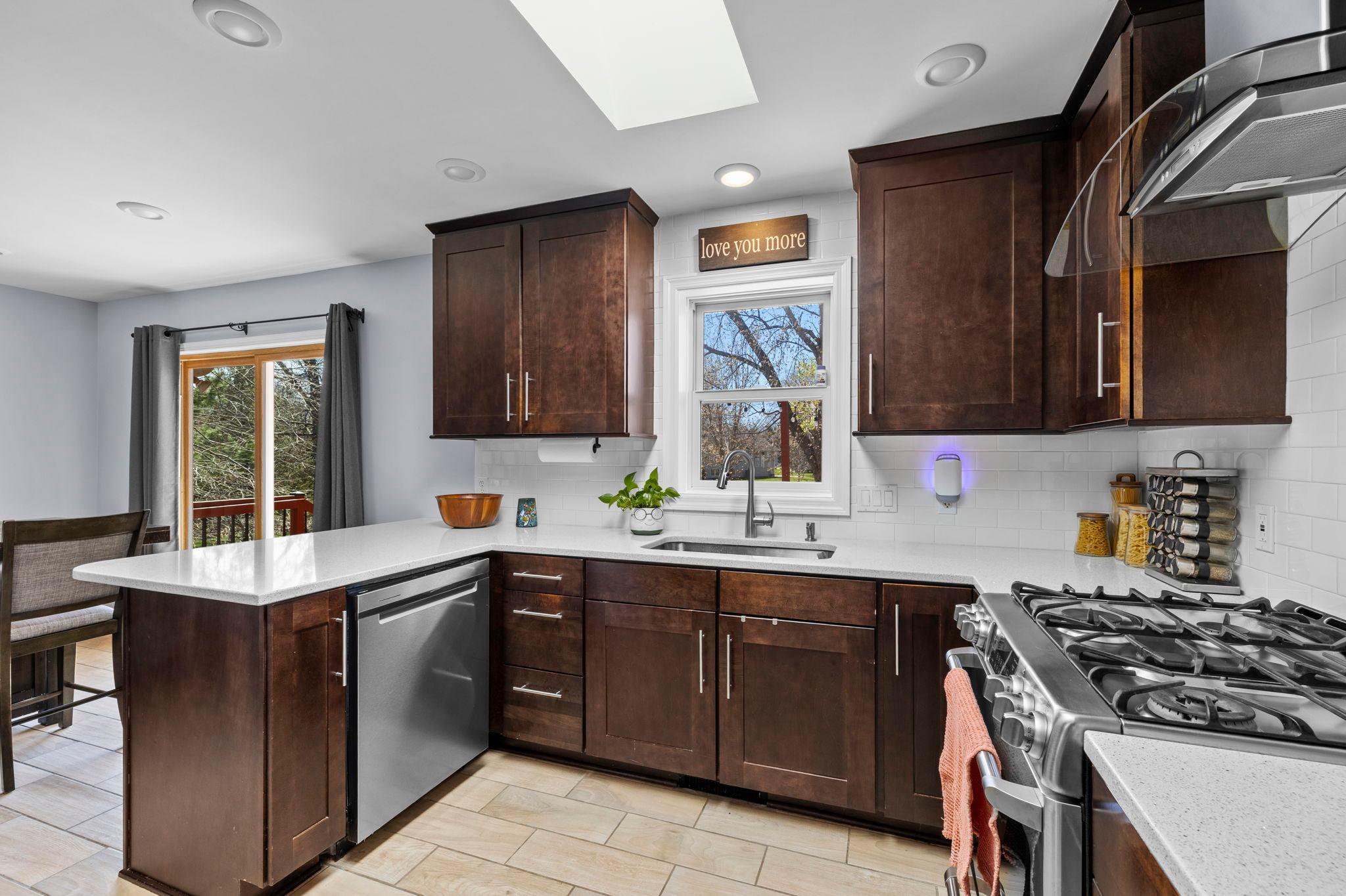 A skylight overhead brings in natural light, while the peninsula offers extra prep space and casual seating.