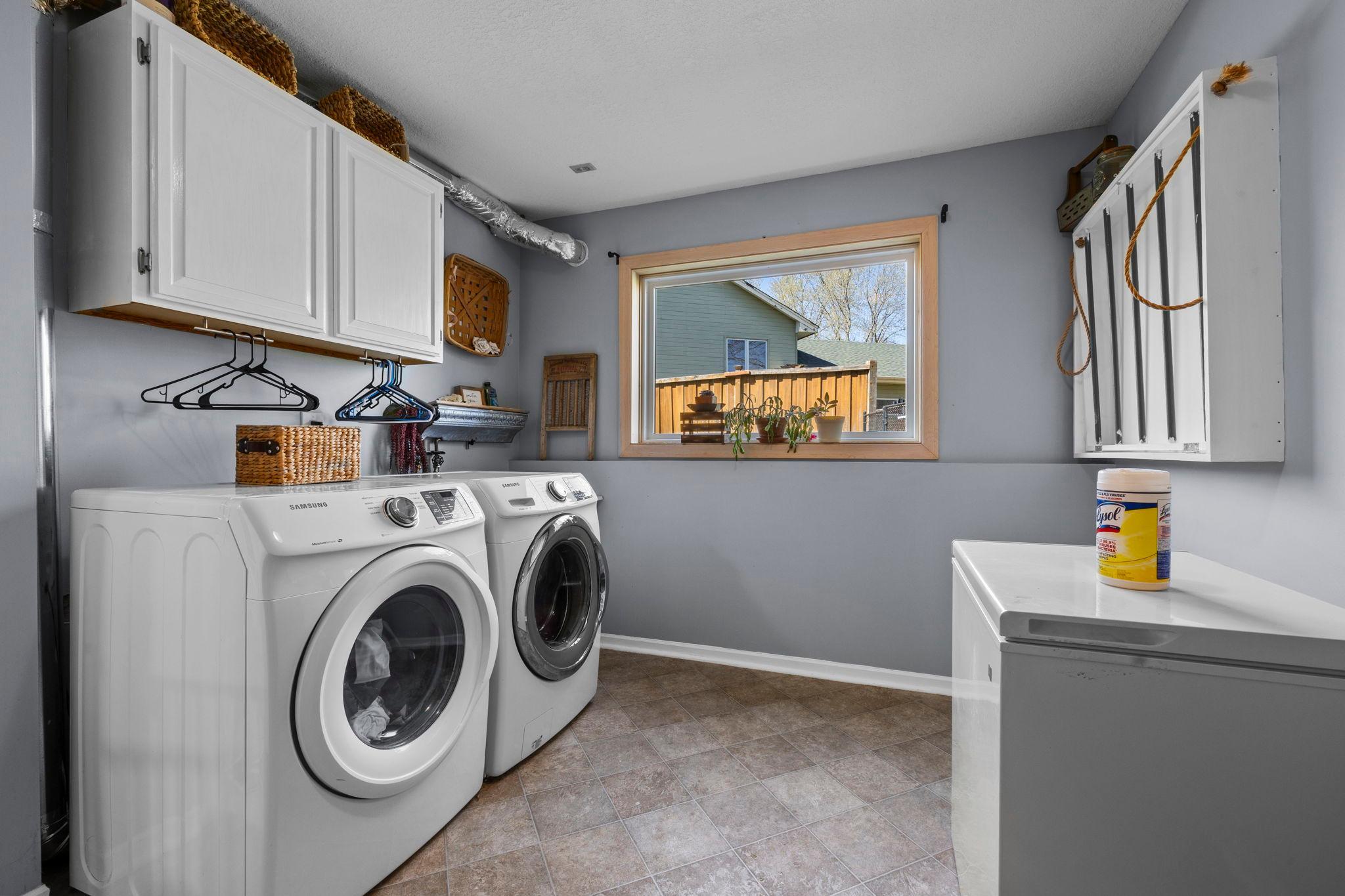 The finished laundry room adds even more convenience, complete with Samsung washer and dryer, cabinetry, a utility sink, and a built-in drying rack.