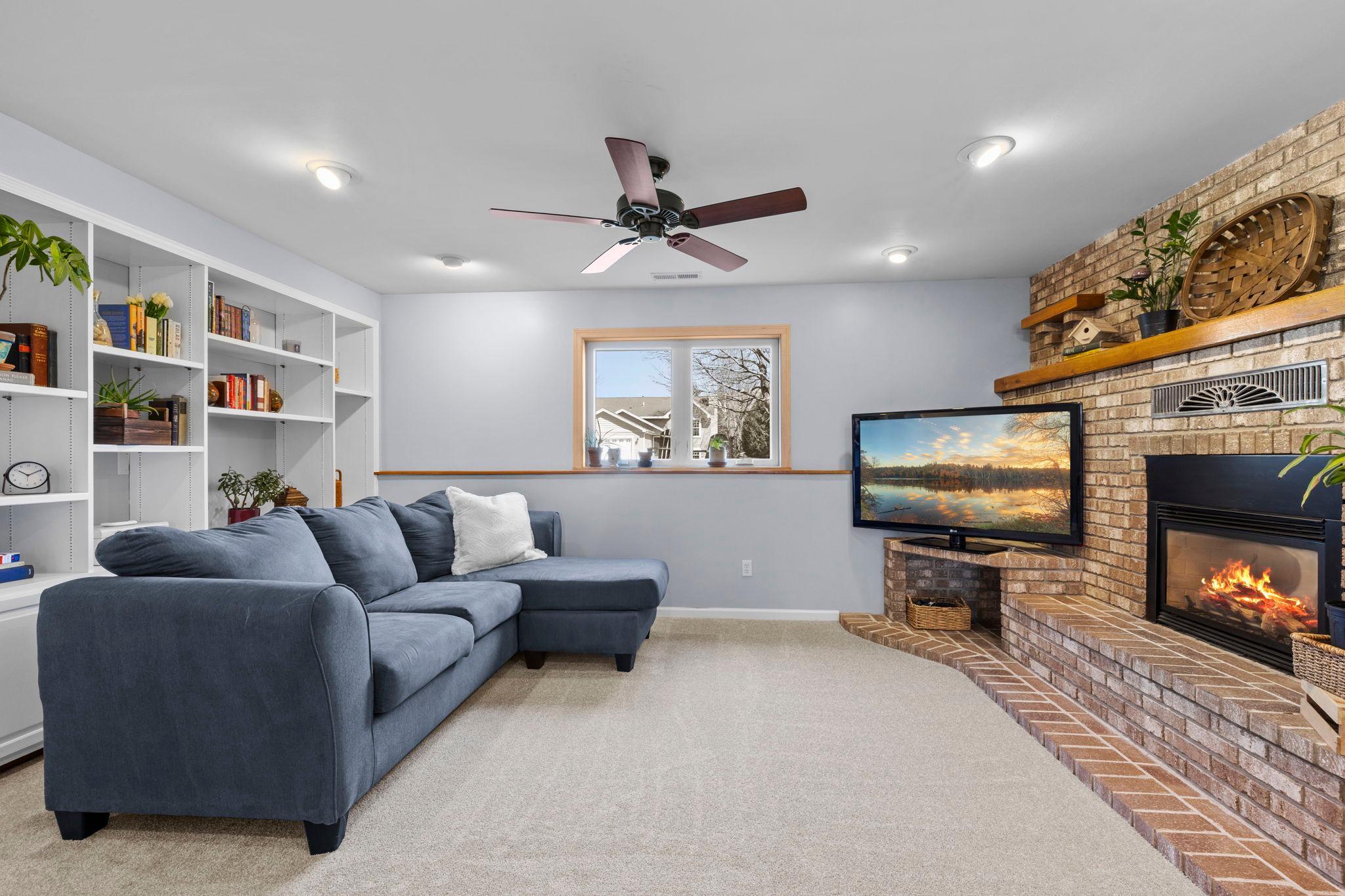 The lower level expands the living space even further, featuring a cozy family room with a brick gas fireplace.