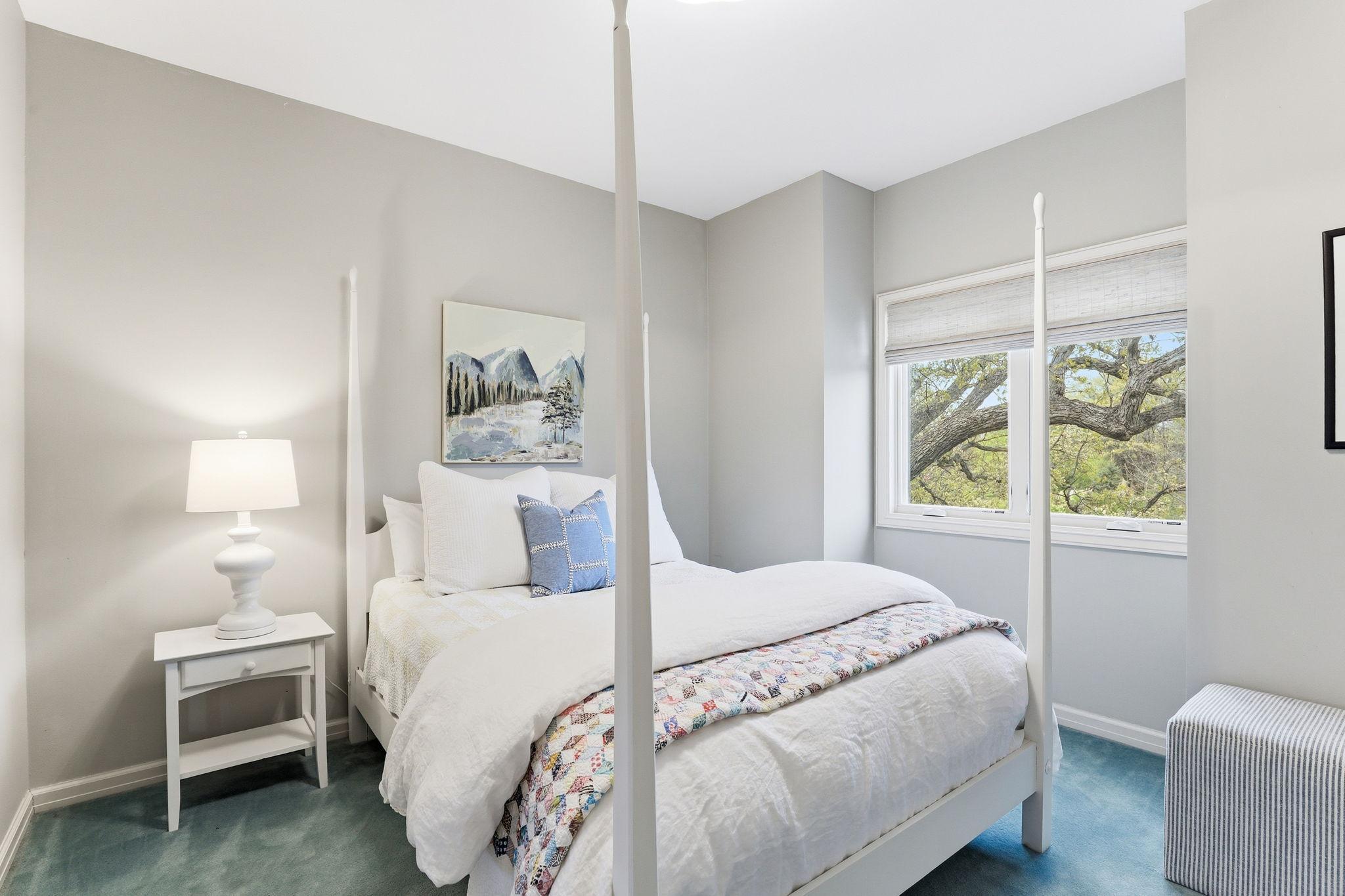 The first of the three additional upper-level bedrooms offers a bright and welcoming atmosphere, featuring generous natural light and refined finishes.
