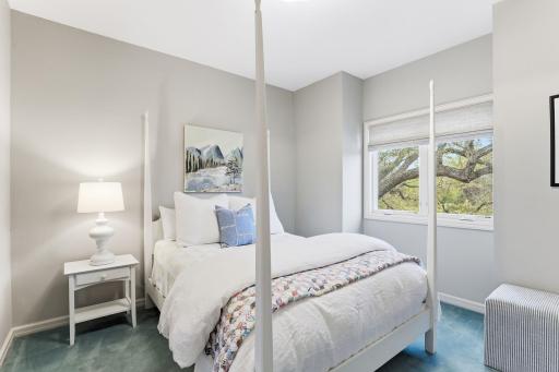 The first of the three additional upper-level bedrooms offers a bright and welcoming atmosphere, featuring generous natural light and refined finishes.