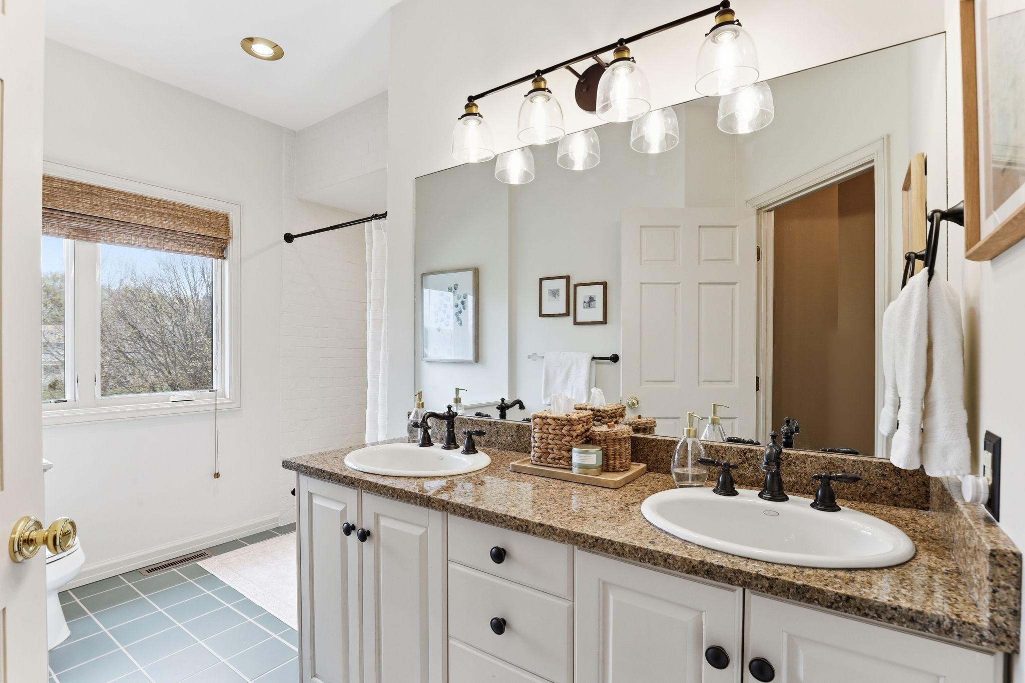 The second full bath on the upper level features elegant finishes and a bright, clean design.