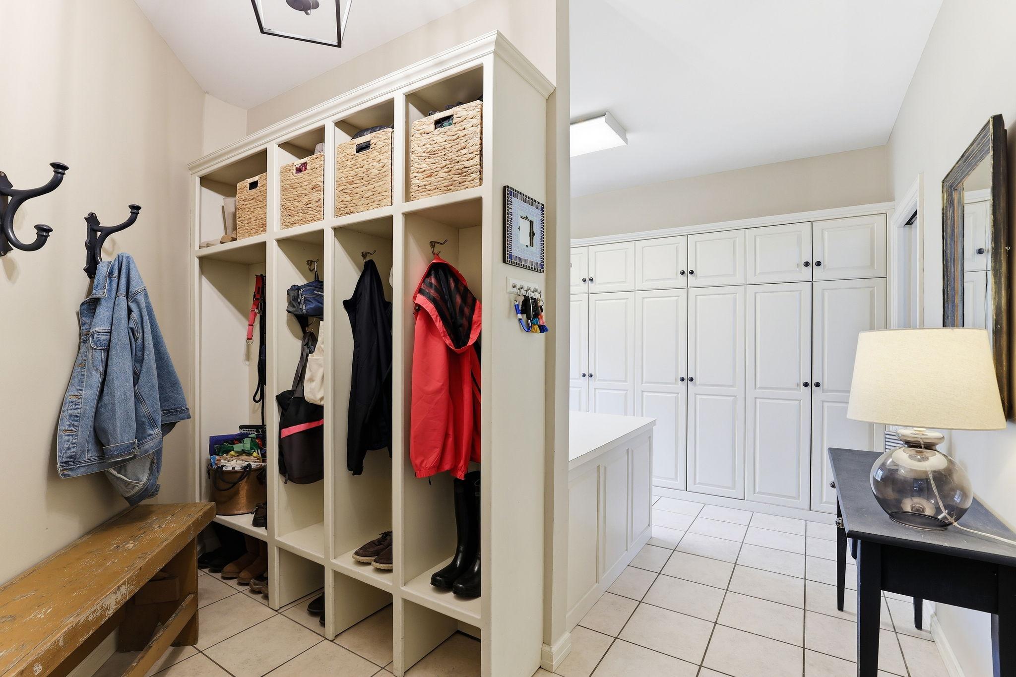 Elegant mudroom connects seamlessly, offering custom cubbies, additional cabinetry, and durable finishes that keep the home tidy and functional without sacrificing style.