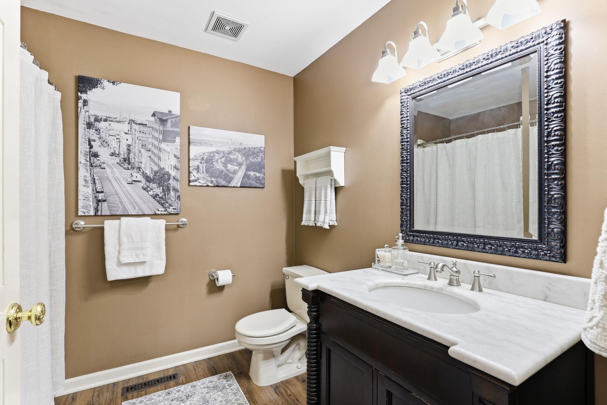 The lower-level full bath features elegant finishes and a bright, clean design, offering both comfort and convenience for guests.
