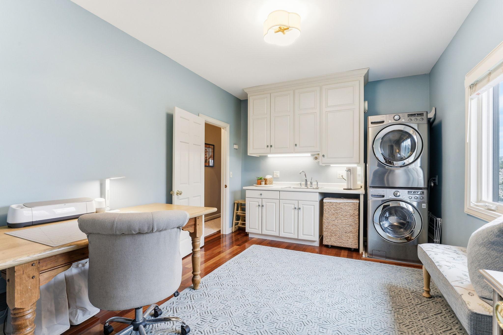 Beautifully designed second-floor laundry room offers both style and function, with warm cabinetry, ample folding space, and premium washer-dryer units.