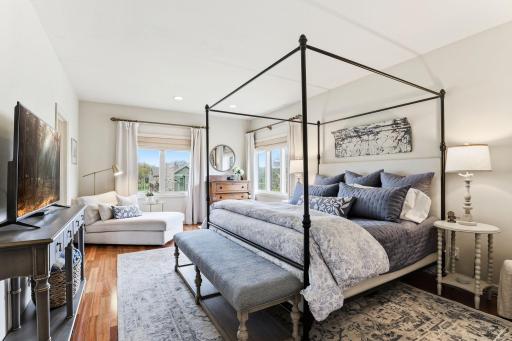 This primary suite blends comfort with luxury, highlighted by beautifully finished hardwood floors and a relaxing atmosphere.
