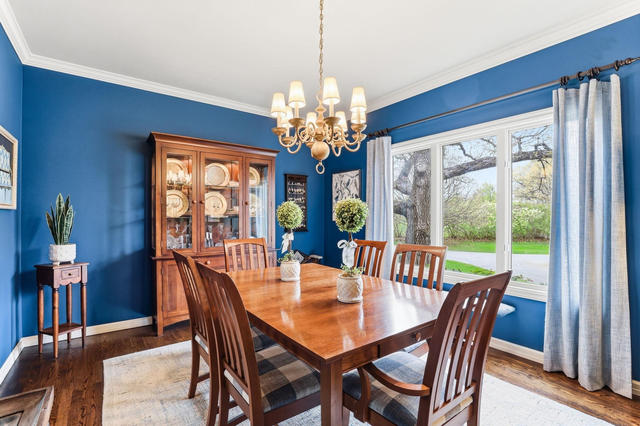 This formal dining room blends luxury with comfort, showcasing a rich hardwood floors, crown molding and large picture window allowing an abundance of natural light.