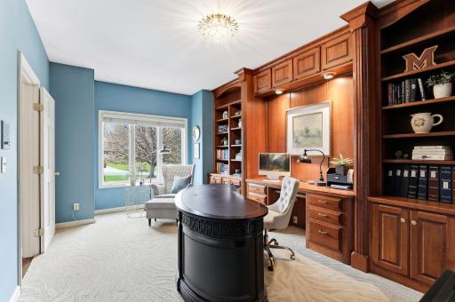 Private study features rich custom built-ins that span the full wall, showcasing detailed craftsmanship and ample storage.