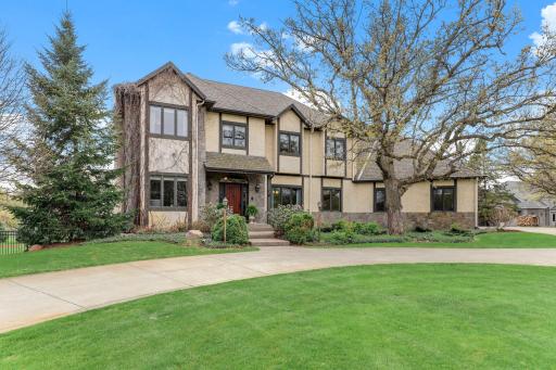Pristine grounds with sculpted landscaping and mature evergreens.
