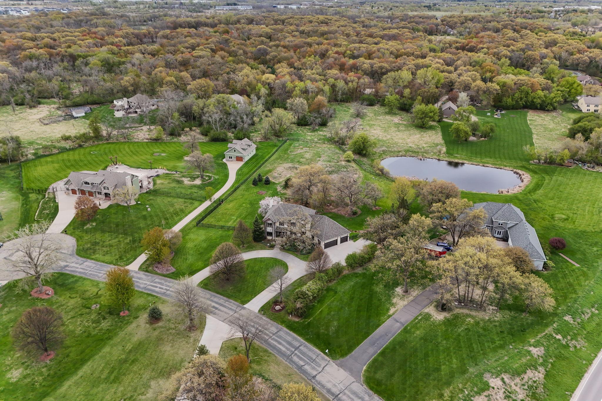 Surrounded by lush greenery and open lawn, the pond adds depth, serenity, and visual interest to the landscape.