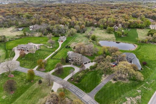 Surrounded by lush greenery and open lawn, the pond adds depth, serenity, and visual interest to the landscape.