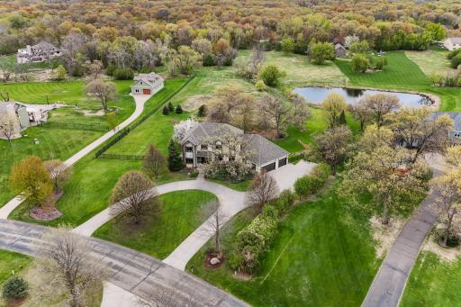 Set on an expansive 2.7-acre estate, the grounds exude timeless luxury, with expansive green space, lush landscaping, and a harmonious blend of open lawn and natural elements.