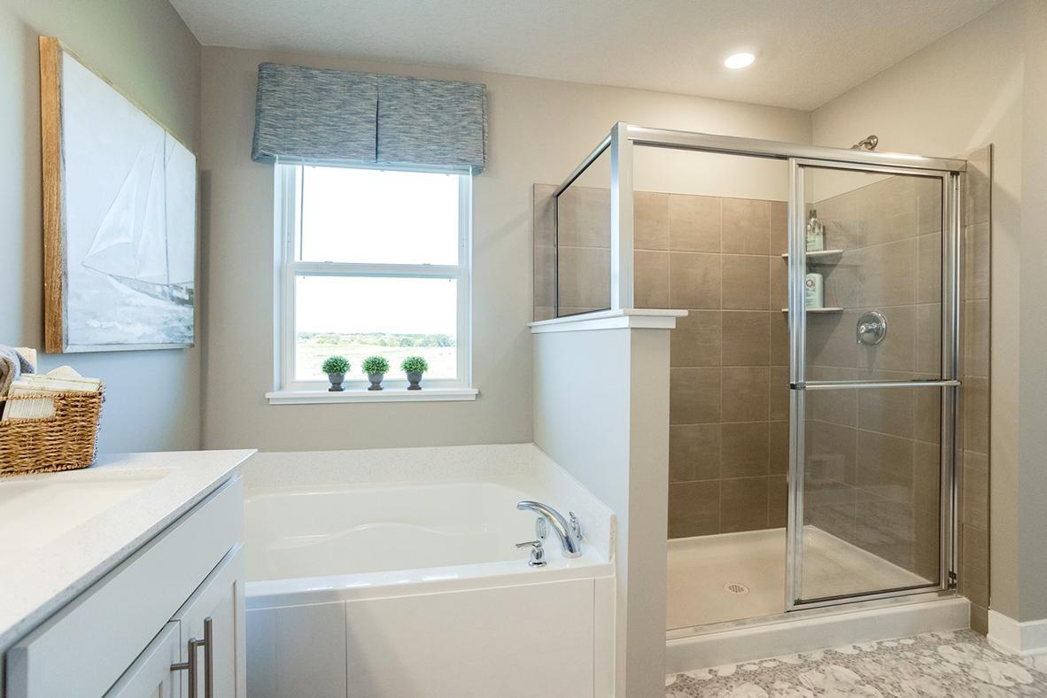 Primary bath with large soaking tub and tile shower.