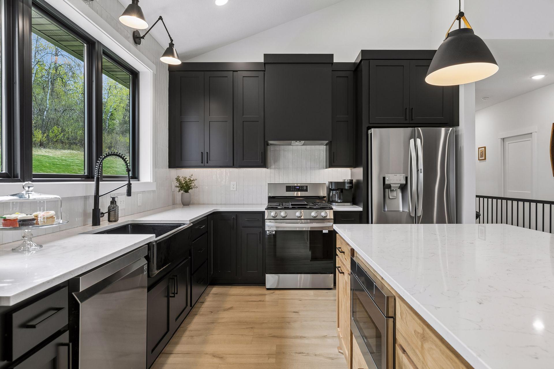 Rich black cabinets, stainless steel appliances and stylish lighting make for a stunning kitchen perfect for your meal preparation and serving