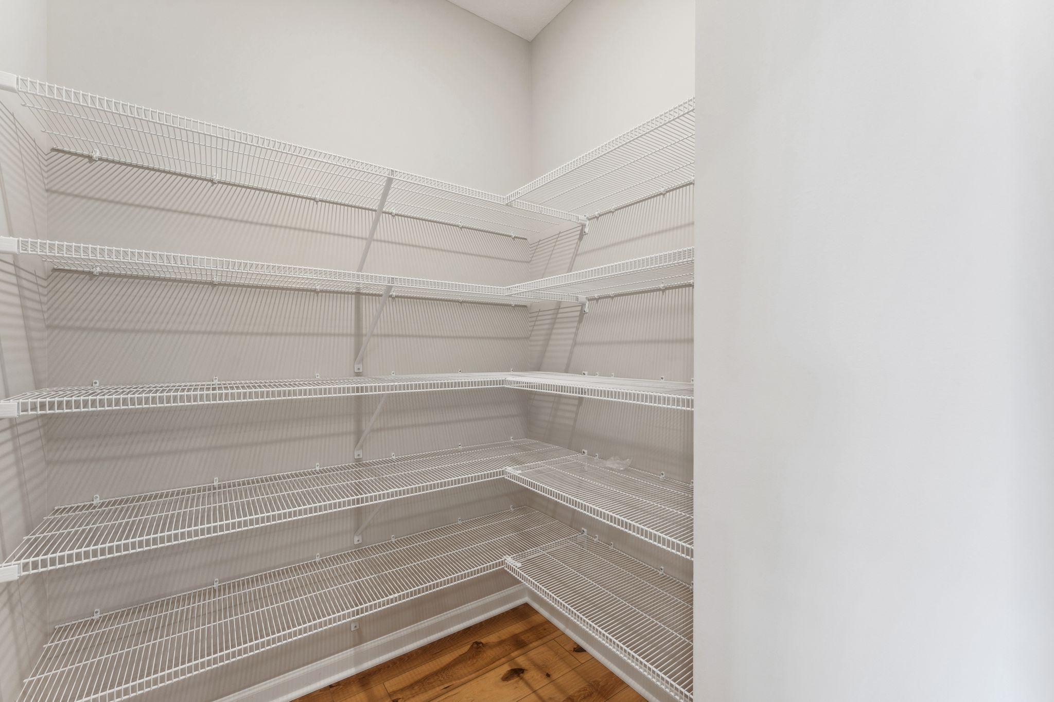 Huge walk-in pantry with abundant shelving for organized storage and easy access to everyday essentials. Similar home shown, color and options can vary.