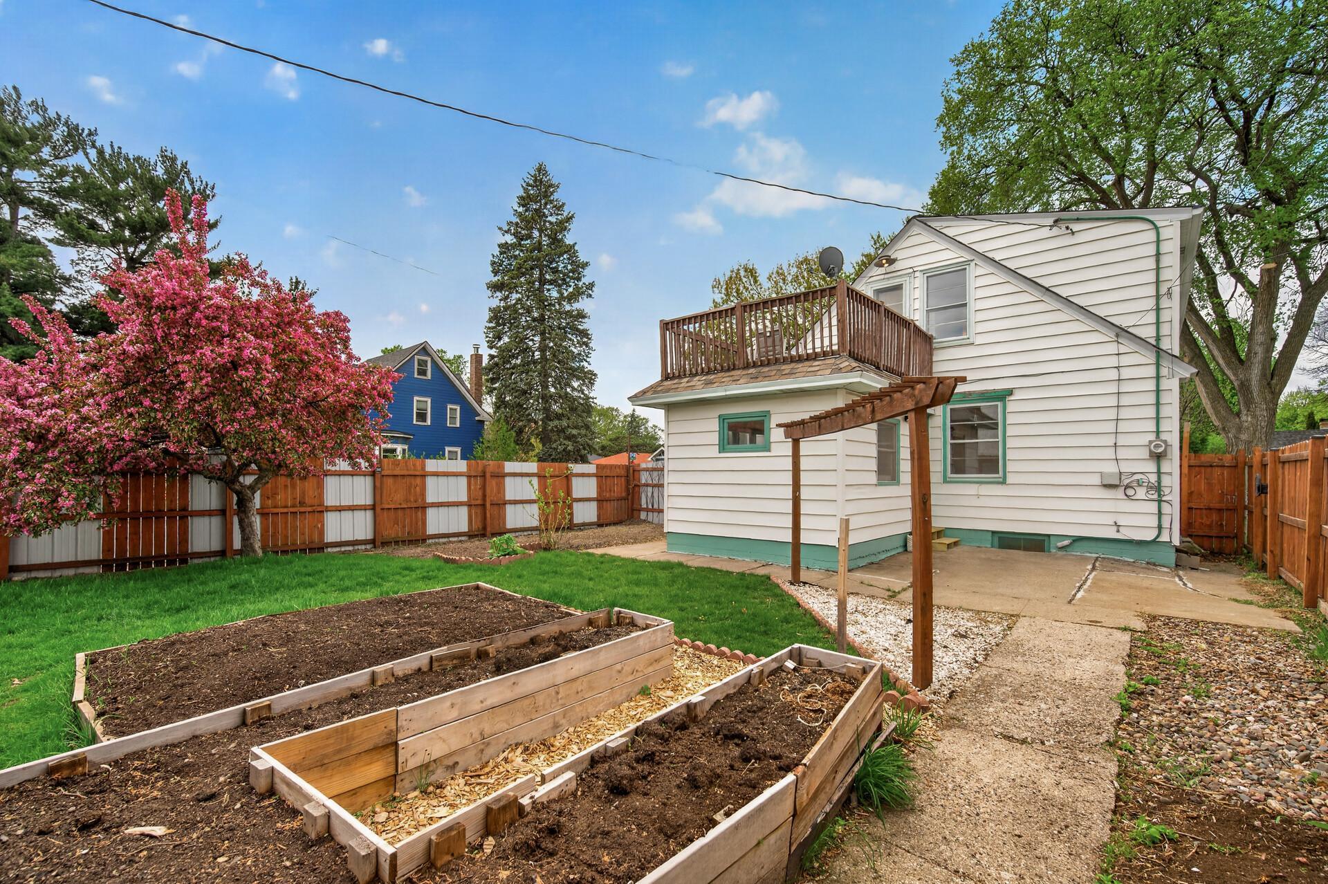 The fully-fenced back yard currently features several garden boxes and a flat soil area ready for planting. Remove and re-seed for a nice level grassy yard for the doggos or kids.