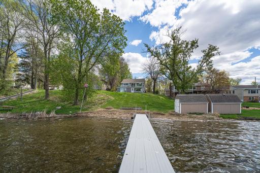 Modern updates include updated flooring, RENOVATED BATHROOMS, a gas fireplace, a four-season porch with a modern hot tub, and updated exterior features including newer vinyl siding and a NEW COMPOSITE DECK with glass railings