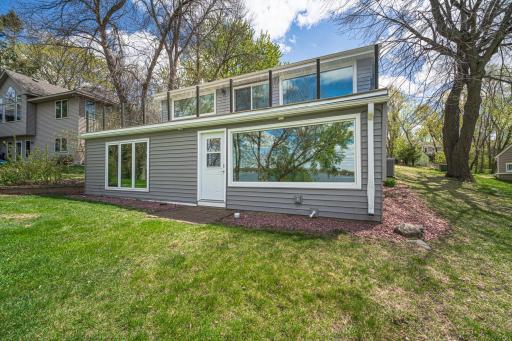 The back of this walkout home showcases the new windows that offer unobstructed views of the lake from nearly every room in the house, including the four-season porch off the lower level.