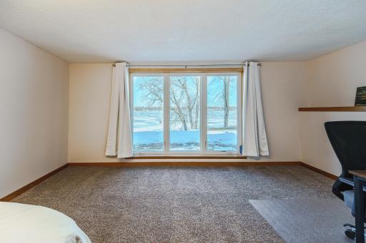 The second bedroom includes a large seating area, and has a HUGE FLOOR-TO-CEILING ANDERSEN WINDOW that showcases the lake view! There is also a large closet.