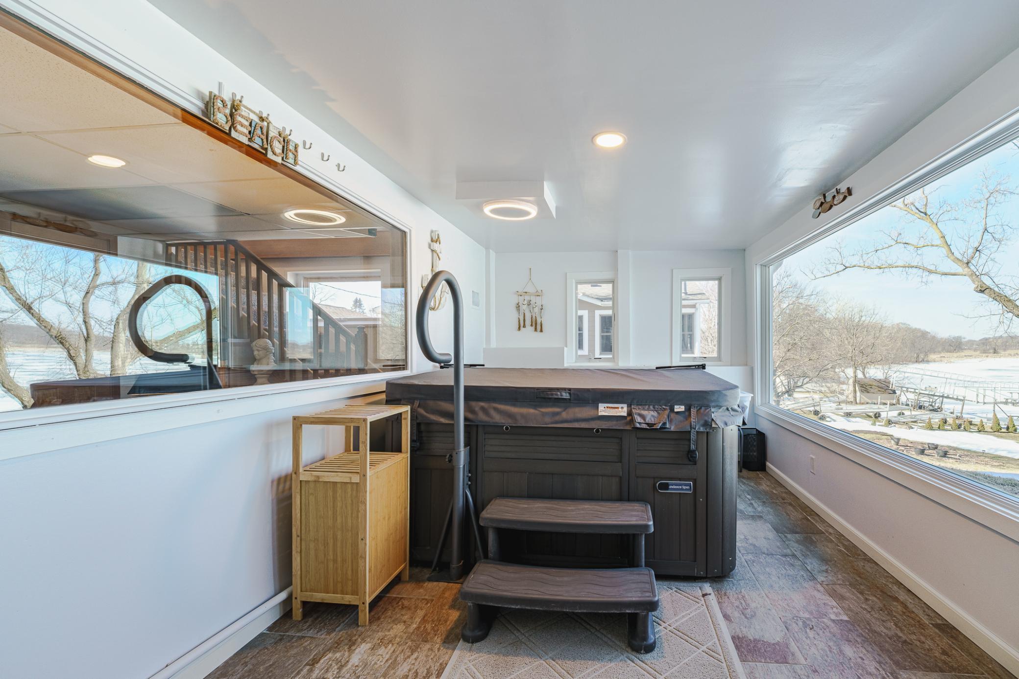 The porch was converted to a crisp and clean four-season room during renovations, and features GIGANTIC NEW ANDERSEN WINDOWS and a modern hot tub by Sundance Spas, from which you can enjoy the expansive views of the lake all year round.