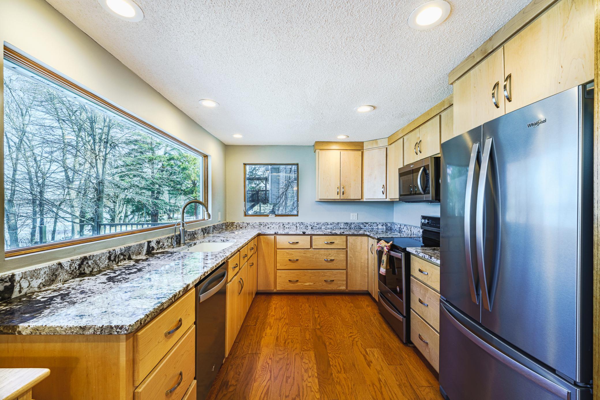 The kitchen layout is functional, and the dramatic Andersen window creates a visual landscape that changes each season.
