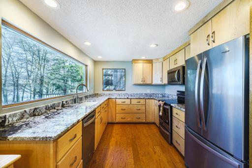 The kitchen layout is functional, and the dramatic Andersen window creates a visual landscape that changes each season.