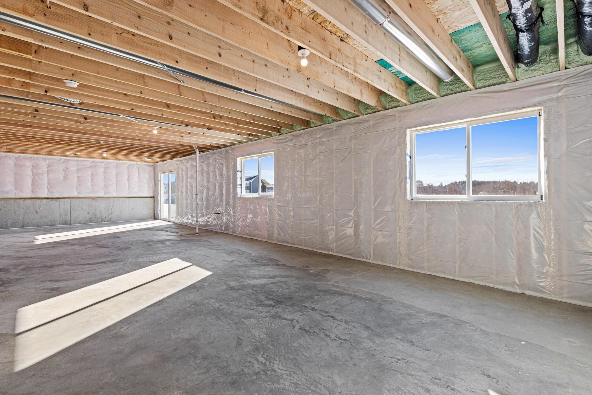 Unfinished Walkout Lower Level. Photo taken of another home with similar plan and finishes. Photos and renderings may not depict actual plan, materials, & finishes may vary. All measurements are approximate.