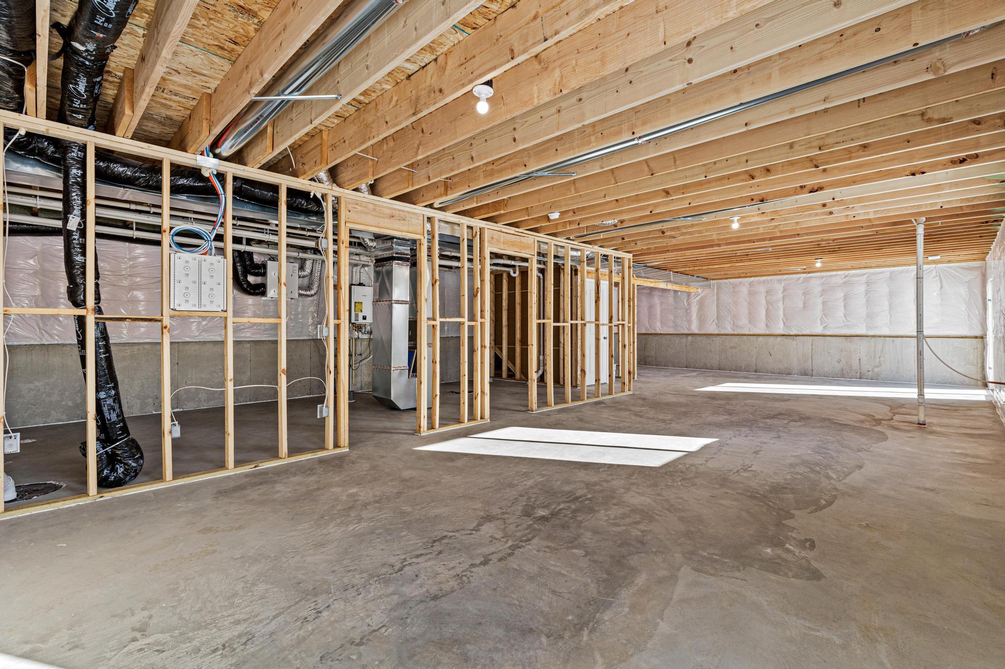Unfinished Walkout Lower Level. Photo taken of another home with similar plan and finishes. Photos and renderings may not depict actual plan, materials, & finishes may vary. All measurements are approximate.