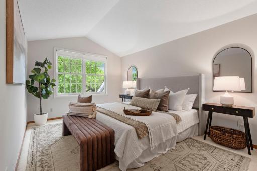 Primary bedroom in upper level with vaulted ceiling