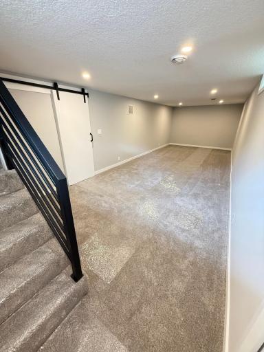 Fully renovated lower level family room with new walls, ceiling, can lighting, and flooring