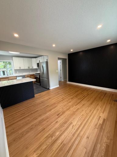 Open-concept kitchen and living room with refinished hardwood floors