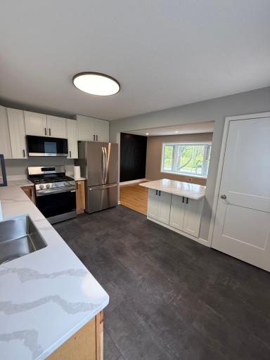 Kitchen features new appliances, cabinetry, lighting, and millwork