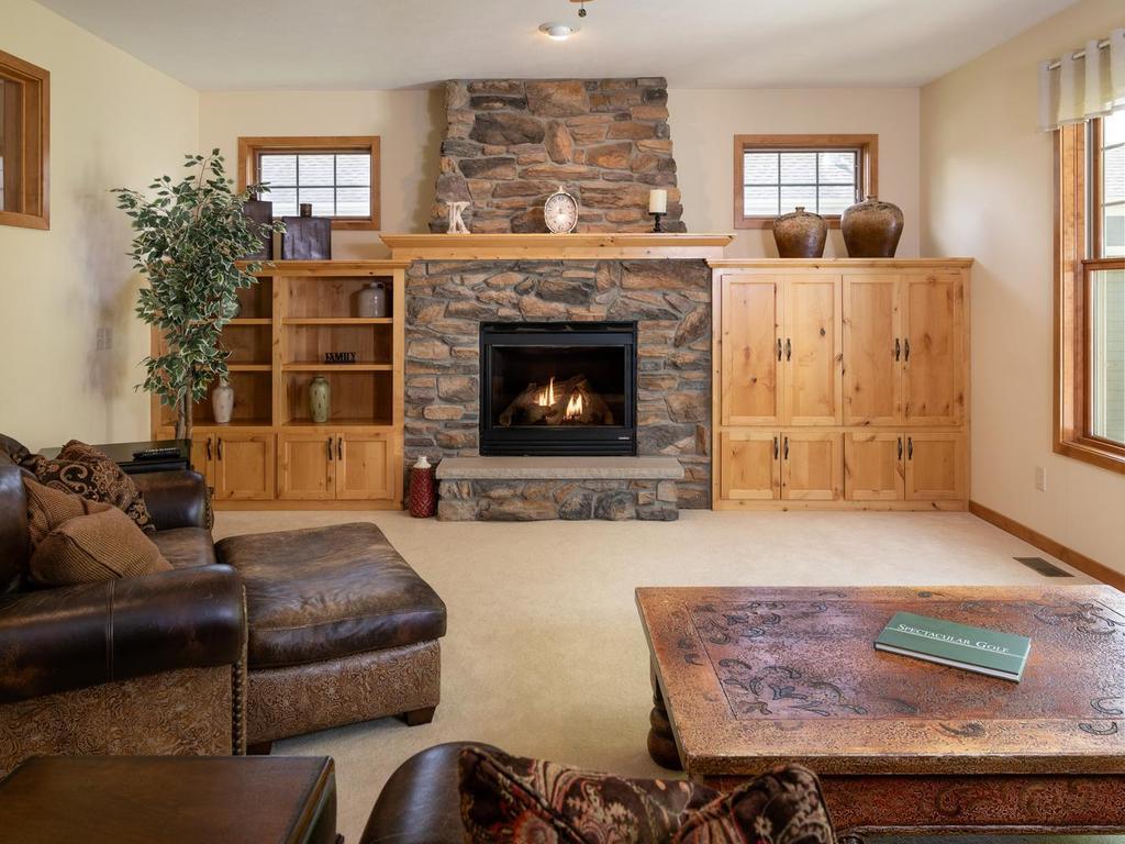 Cozy family room with gas fireplace, built-in cabinets/shelves, and transom windows.