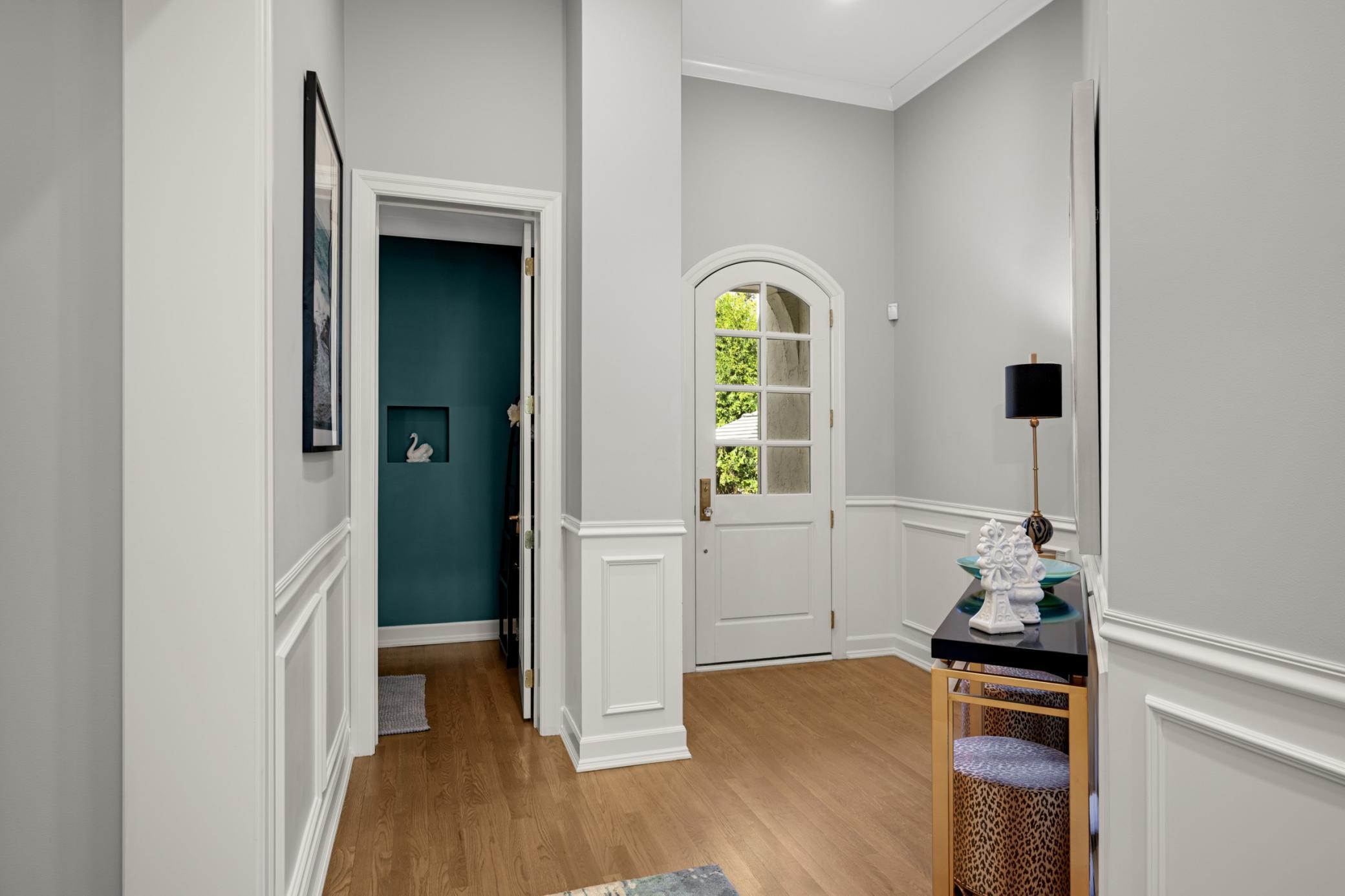 The welcoming foyer accesses the pretty powder room, mudroom, laundry room, and leads to the attached heated garage