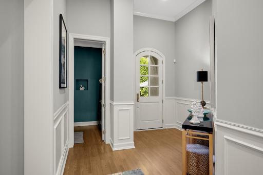 The welcoming foyer accesses the pretty powder room, mudroom, laundry room, and leads to the attached heated garage