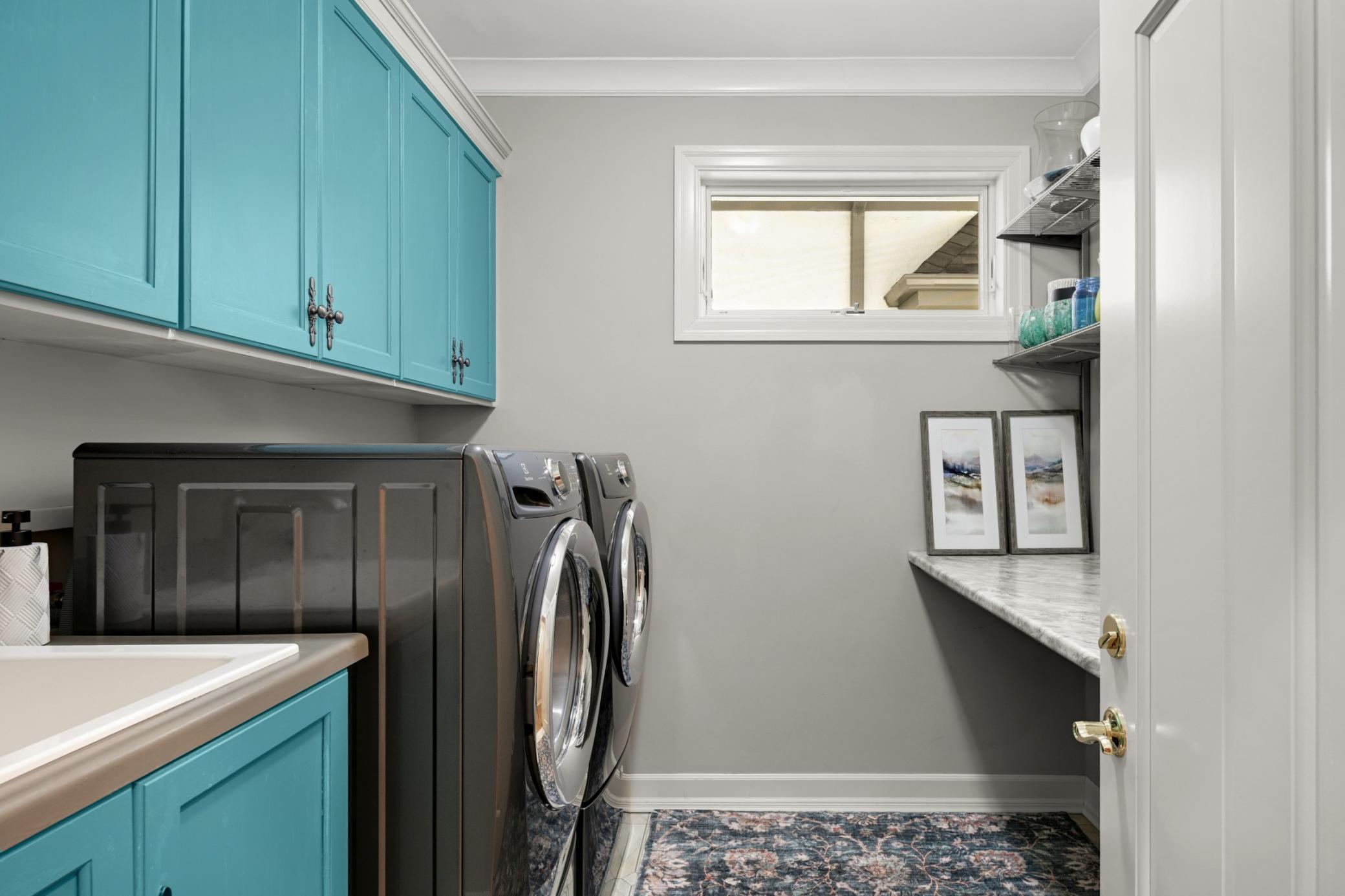 The main floor laundry with an added sink, cabinets, a folding counter and a window