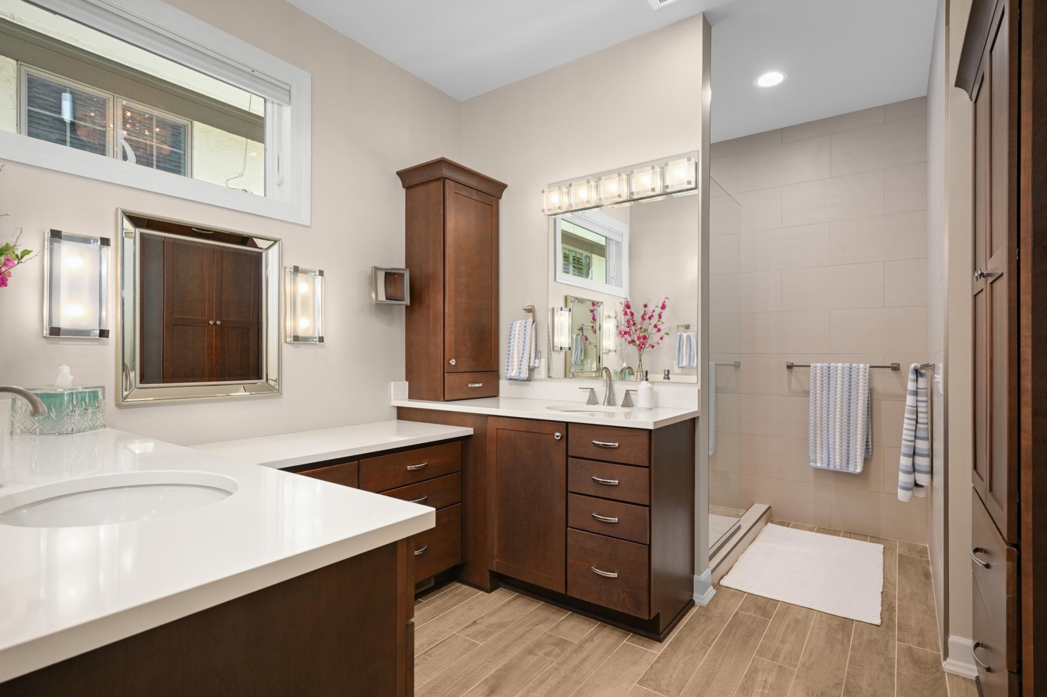 A fully remodeled primary bath that offers 2 separate sinks, a makeup vanity and a nice sized walk-in shower.