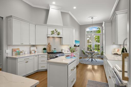 The Remodeled center Island kitchen features enameled cabinetry, Cambria Quartzsite countertops, a farm sink and a pretty backsplash