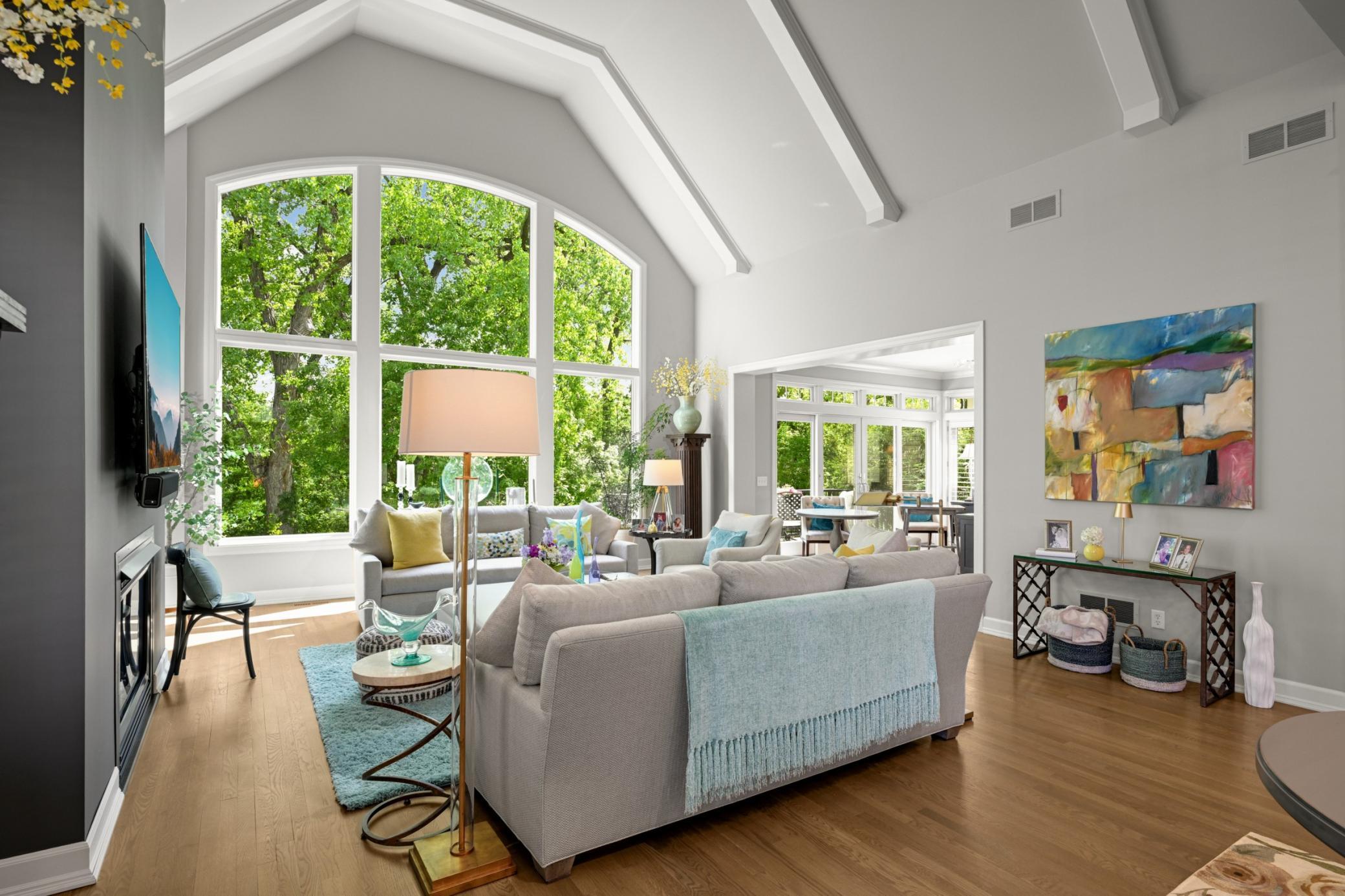 A vast arched two-story window with panoramic views of the lake.