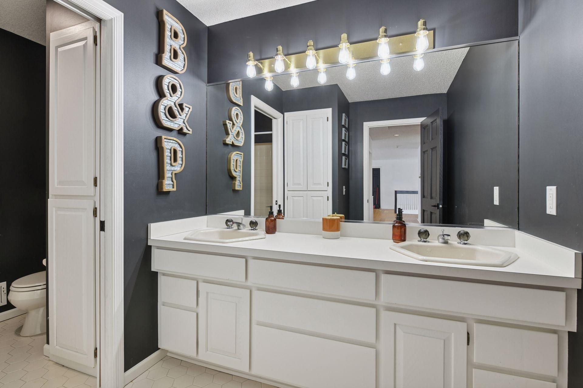 Upper level full bathroom with dual vanity, ample storage space, and separate W/C.